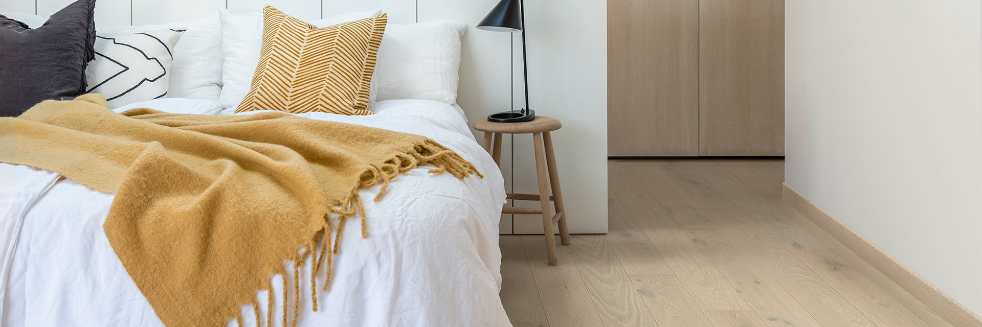 slaapkamer met beige hardhouten vloeren en bijpassende plinten